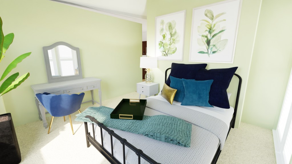 View of bed head on, standing near the window facing the door. You can see the fun pillows covering the bed with two large plant like photography prints hung on the wall above.