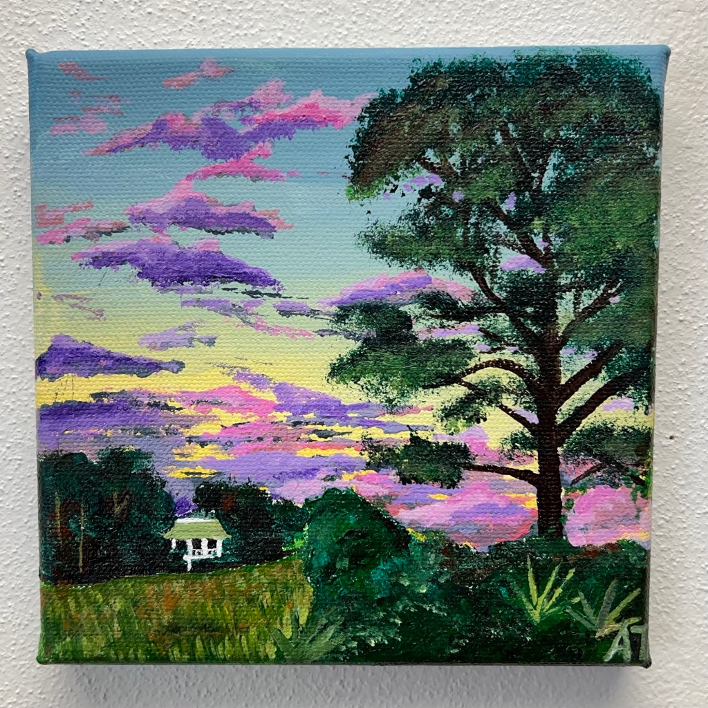 a tall loblolly pine stands tall to the right overlooking a green marshy grass, across sits a peninsula full of trees where a small white house is perched. The sky striped with deep purple and lavender clouds with hints of pink.