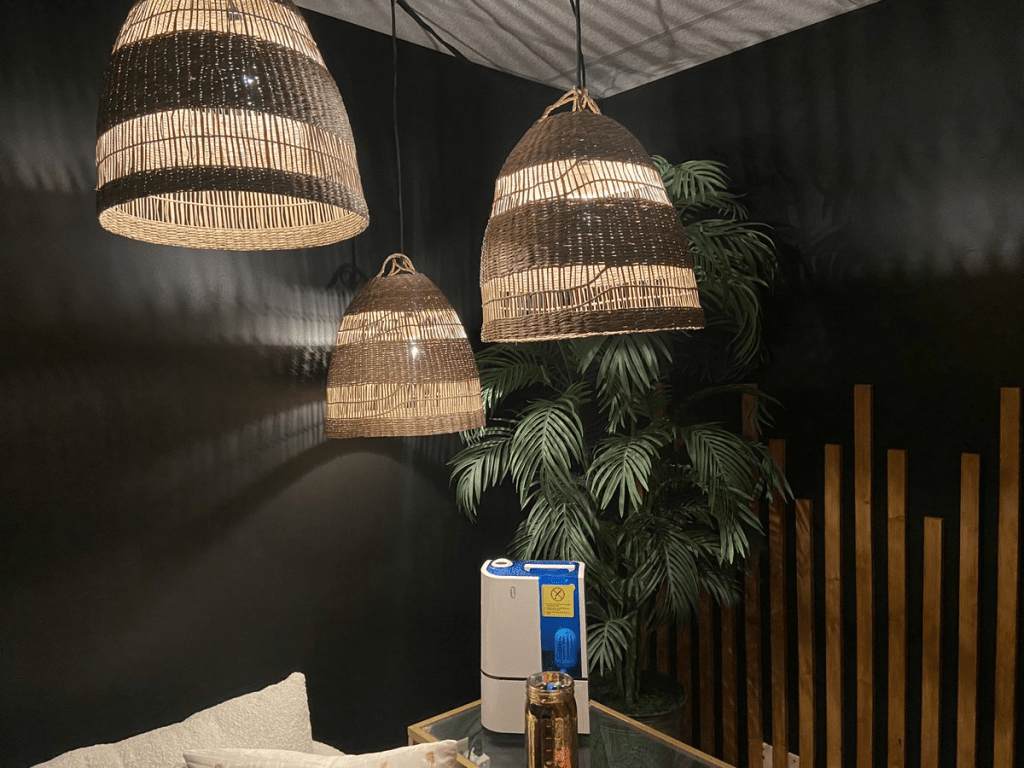 Three rattan pendants all warmly glowing and dispersing a soft light into a black painted corner of my living room.